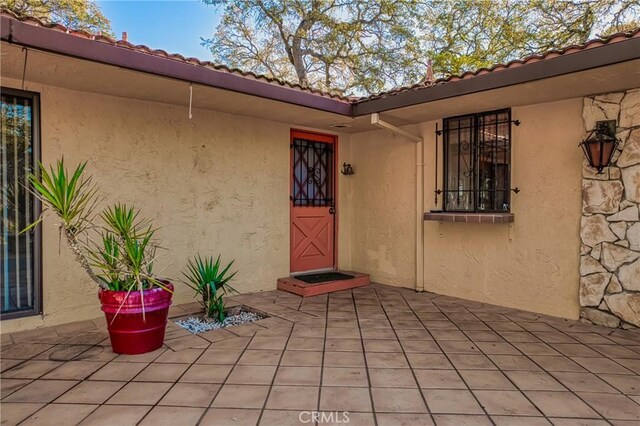 view of exterior entry with a patio