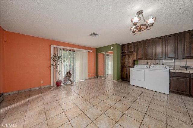laundry room with light tile patterned floors, visible vents, an inviting chandelier, separate washer and dryer, and cabinet space