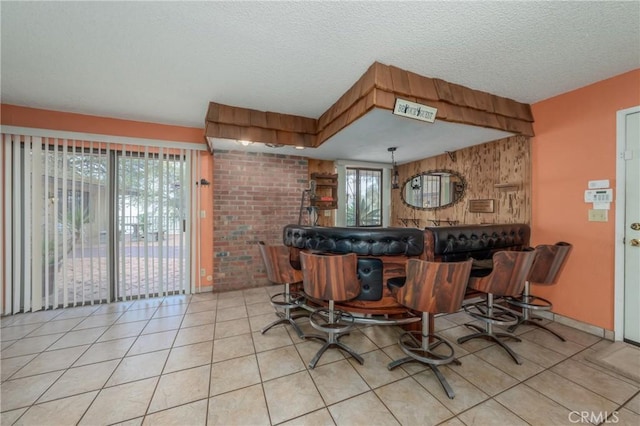 kitchen featuring a textured ceiling, wooden walls, and tile patterned flooring
