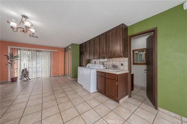 kitchen featuring tasteful backsplash, tile counters, light tile patterned floors, and a chandelier