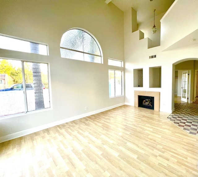 unfurnished living room with a high ceiling and light hardwood / wood-style flooring