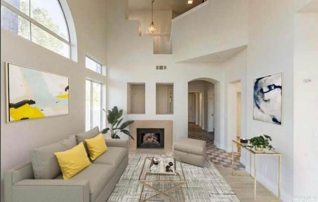 living room featuring a towering ceiling and light hardwood / wood-style flooring