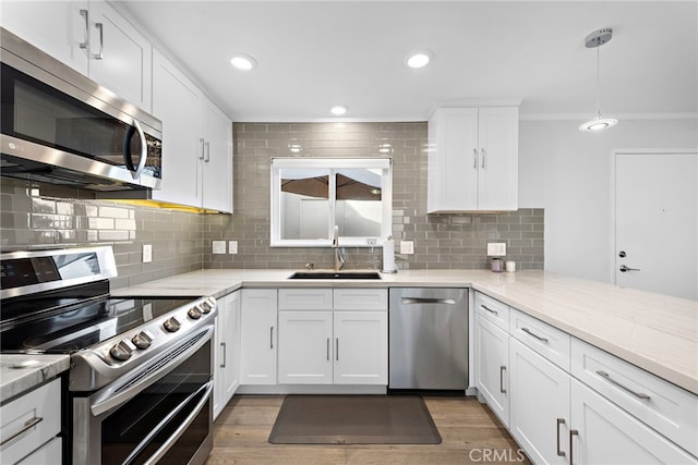 kitchen with white cabinetry, sink, dark wood-type flooring, decorative backsplash, and appliances with stainless steel finishes