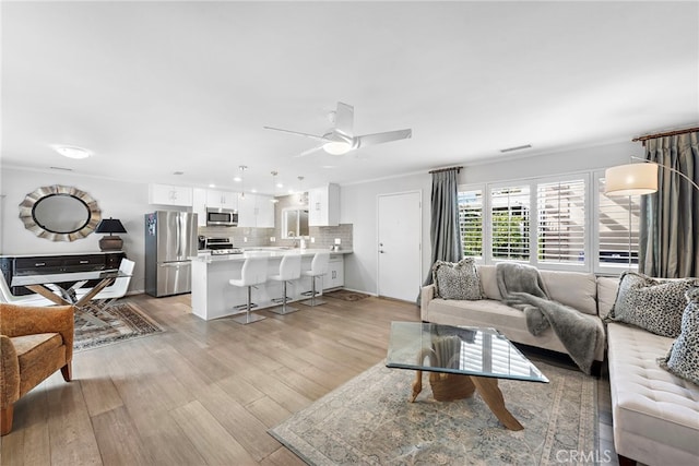 living room featuring ceiling fan and light wood-type flooring