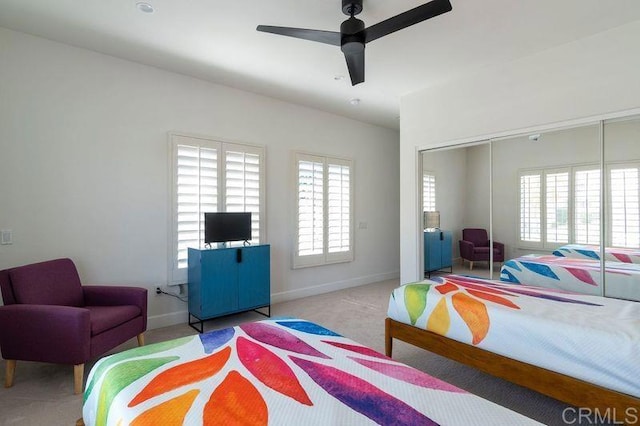 carpeted bedroom featuring ceiling fan, baseboards, and a closet