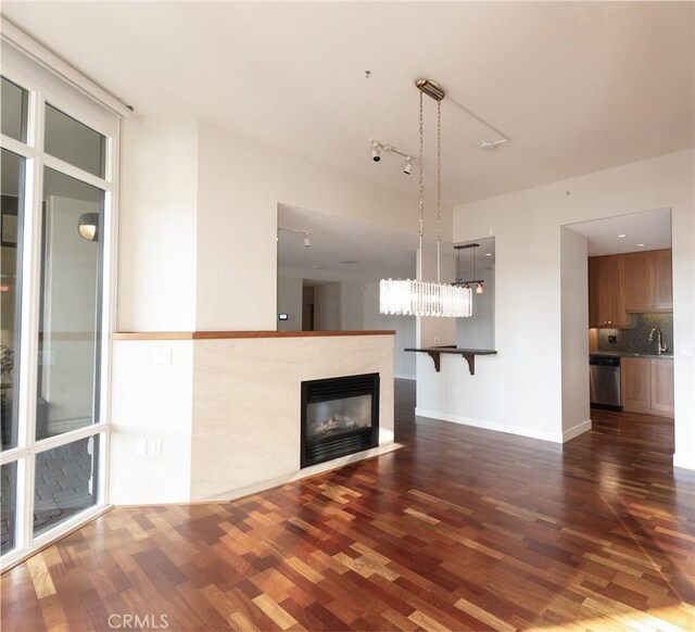 700 W Harbor Dr Unit 104, San Diego, CA 92101 - unfurnished living room with dark wood-style floors, a high end fireplace, a sink, and baseboards