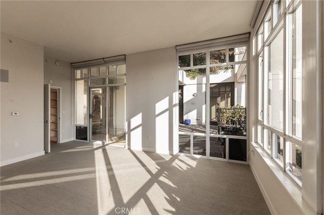 unfurnished room with carpet floors and baseboards