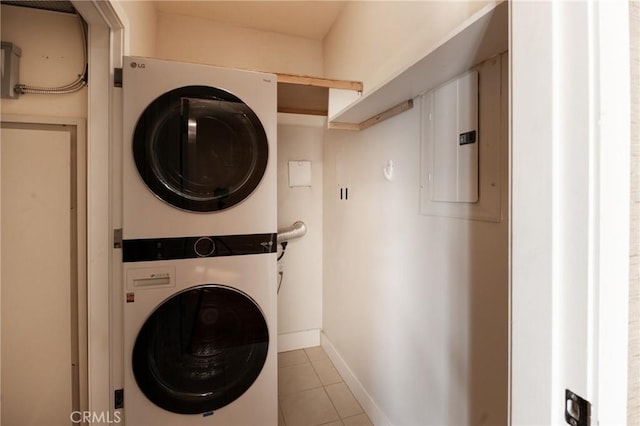 700 W Harbor Dr Unit 104, San Diego, CA 92101 - clothes washing area with estacked washer and dryer, electric panel, tile patterned flooring, and baseboards