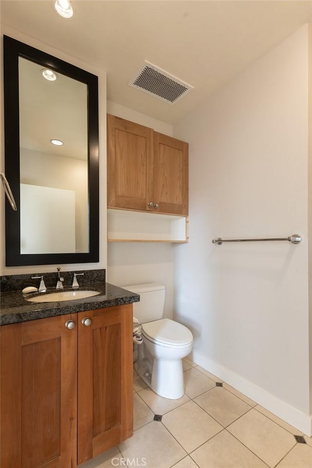 half bathroom featuring vanity, toilet, tile patterned floors, baseboards, and visible vents