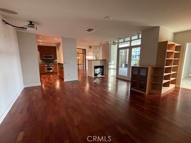 700 W Harbor Dr Unit 104, San Diego, CA 92101 - unfurnished living room featuring dark wood-style floors and a fireplace
