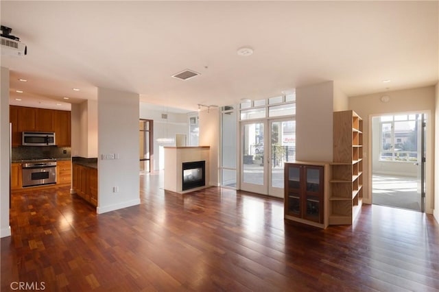 700 W Harbor Dr Unit 104, San Diego, CA 92101 - unfurnished living room featuring dark wood-style floors, a multi sided fireplace, recessed lighting, and french doors