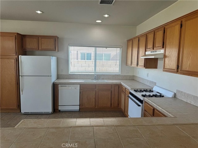 kitchen featuring tile countertops, sink, light tile patterned floors, and white appliances