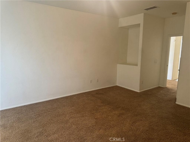 unfurnished room with dark colored carpet