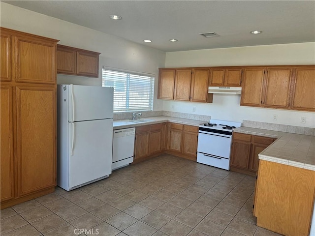 kitchen featuring white appliances, sink, and light tile patterned floors