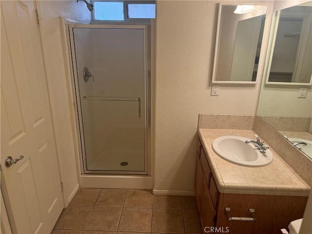 bathroom featuring tile patterned floors, vanity, and walk in shower