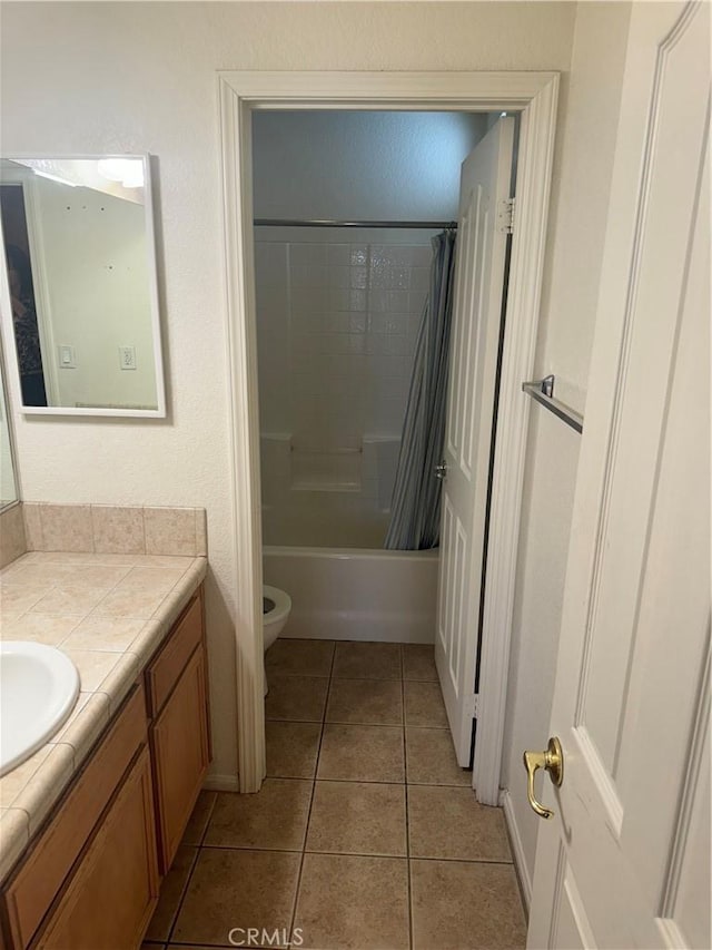 full bathroom featuring tile patterned flooring, vanity, toilet, and shower / tub combo with curtain