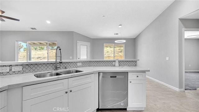 kitchen featuring tasteful backsplash, white cabinetry, sink, and stainless steel dishwasher