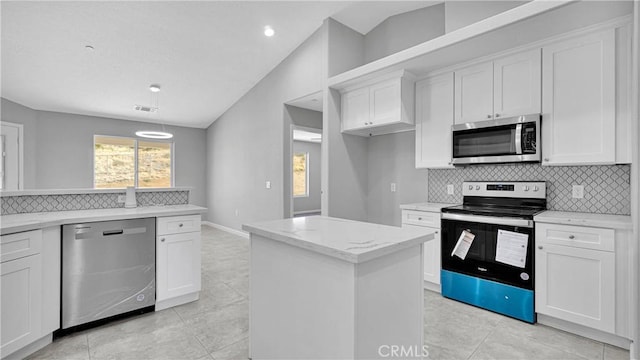 kitchen featuring white cabinets, light stone countertops, lofted ceiling, and appliances with stainless steel finishes