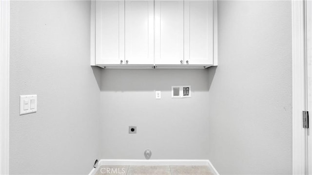 washroom with hookup for an electric dryer, hookup for a washing machine, light tile patterned floors, and cabinets