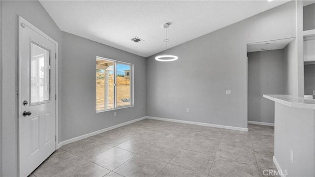 tiled empty room with vaulted ceiling