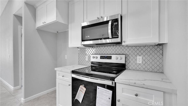 kitchen featuring decorative backsplash, light stone counters, white cabinetry, and appliances with stainless steel finishes