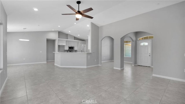 unfurnished living room featuring light tile patterned floors, high vaulted ceiling, and ceiling fan