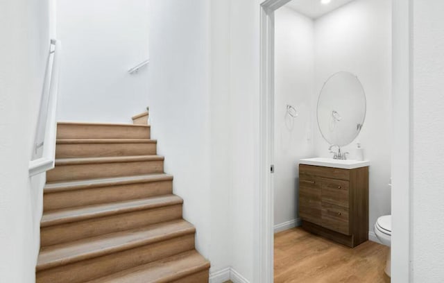 stairway with wood-type flooring and sink