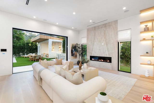 living room featuring light hardwood / wood-style floors and a large fireplace