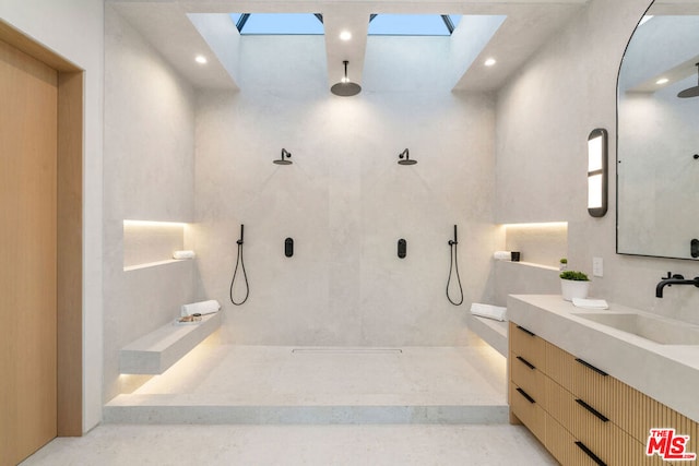 bathroom featuring a shower, a skylight, and vanity