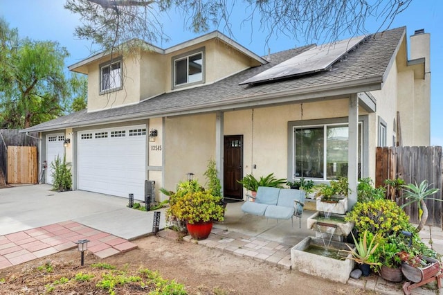 view of front facade featuring solar panels and a garage