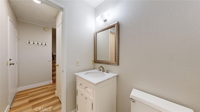 bathroom featuring wood-type flooring, vanity, and toilet