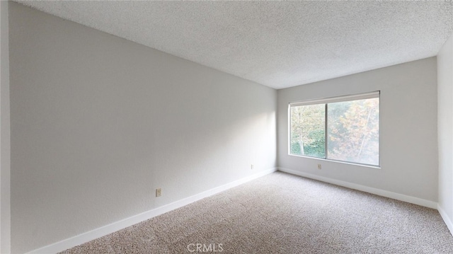 unfurnished room featuring carpet flooring and a textured ceiling