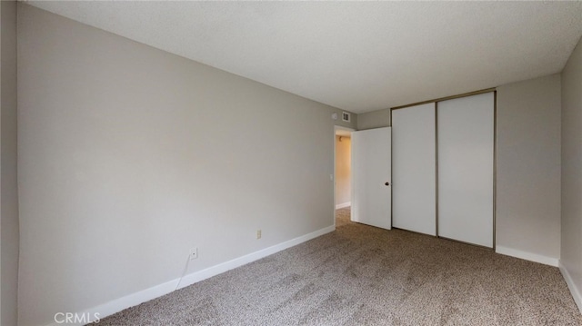 unfurnished bedroom with a closet, carpet floors, and a textured ceiling