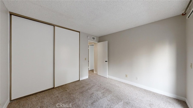 unfurnished bedroom featuring light colored carpet and a textured ceiling