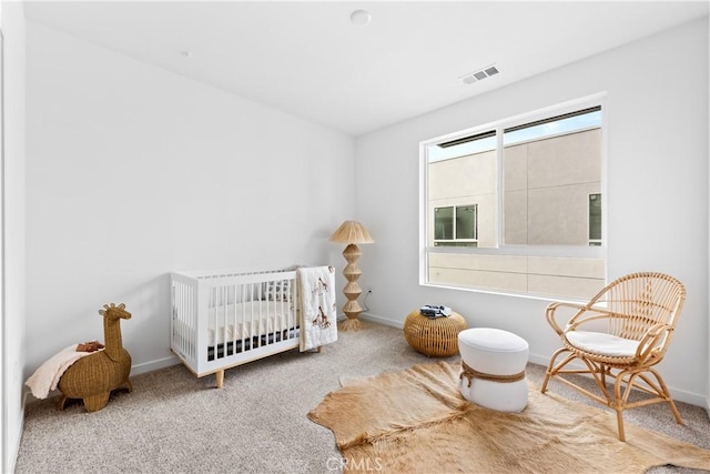 carpeted bedroom featuring a crib