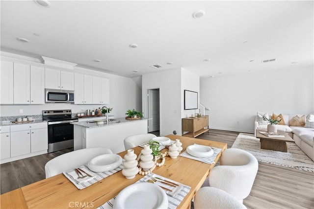 dining area with wood-type flooring and sink