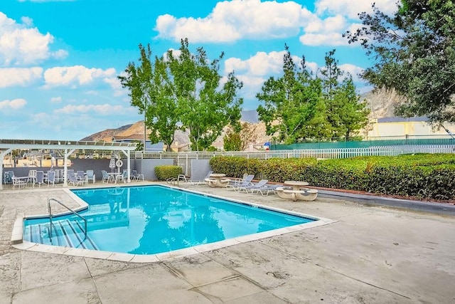 view of pool with a mountain view and a patio