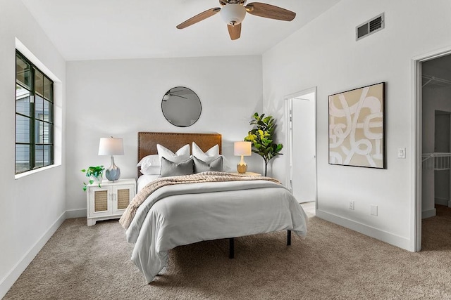 bedroom featuring carpet flooring, ceiling fan, a walk in closet, and lofted ceiling