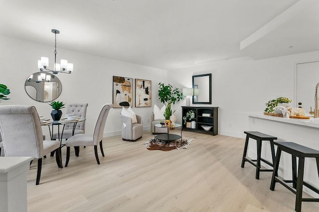 living room with light hardwood / wood-style floors and an inviting chandelier