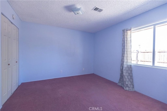 spare room with carpet flooring and a textured ceiling