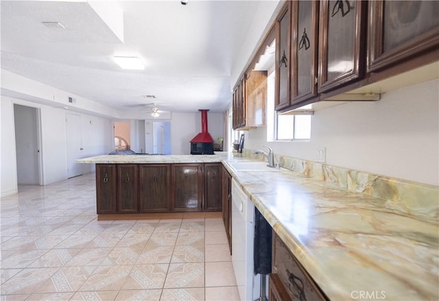 kitchen featuring dark brown cabinetry, ceiling fan, sink, kitchen peninsula, and light tile patterned floors