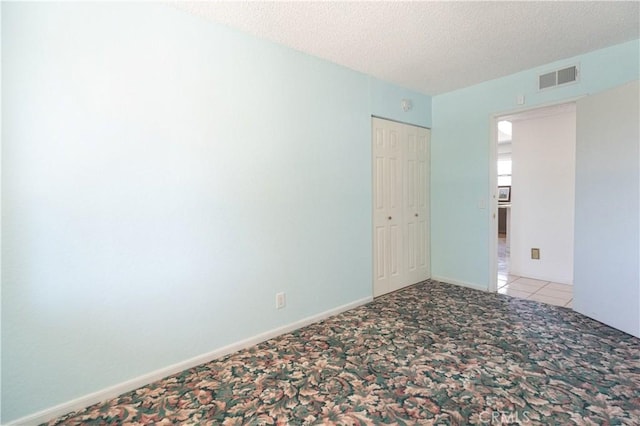 carpeted spare room with a textured ceiling