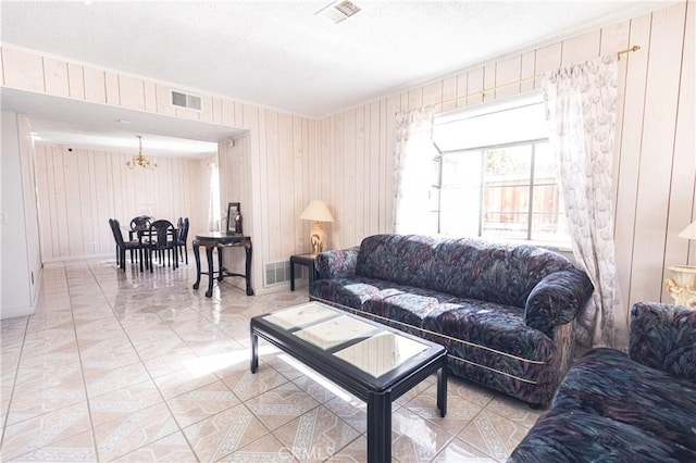 living room featuring wooden walls and an inviting chandelier