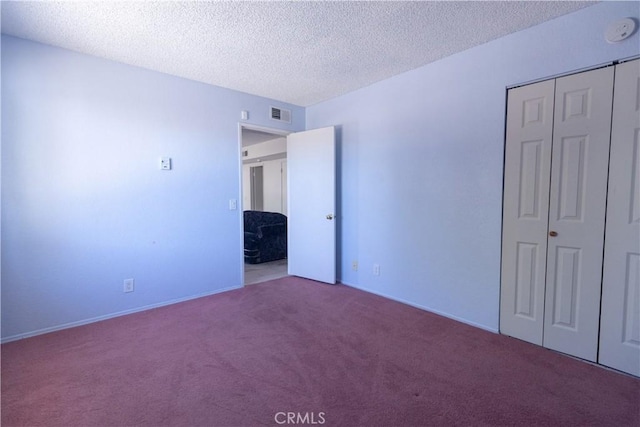 unfurnished bedroom with carpet flooring, a closet, and a textured ceiling