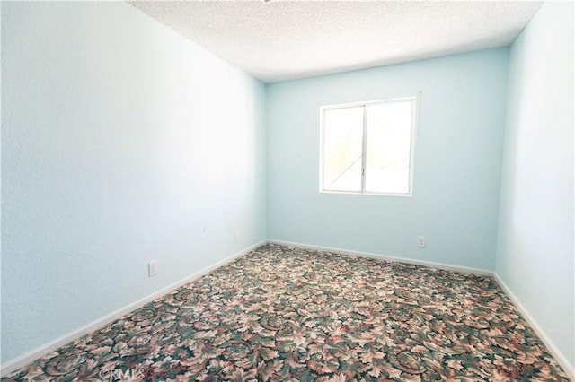 carpeted empty room with a textured ceiling