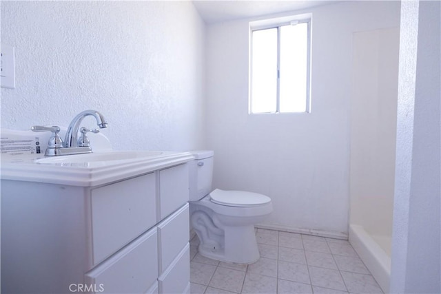 bathroom featuring tile patterned floors, vanity, toilet, and a shower