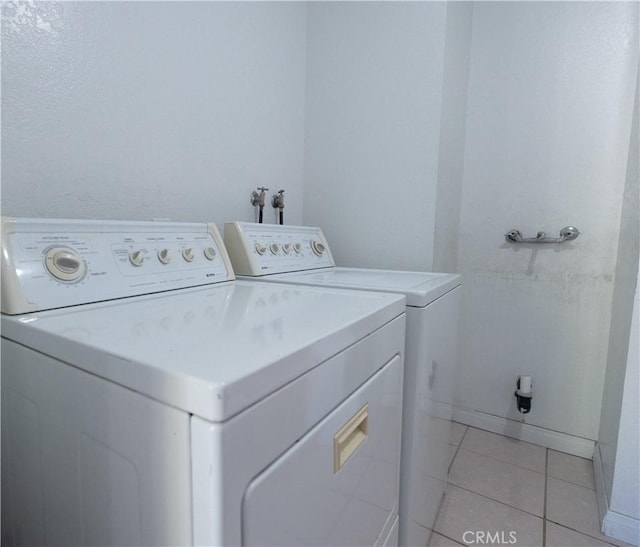 washroom featuring washing machine and clothes dryer and light tile patterned floors