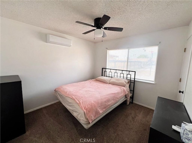 bedroom with ceiling fan, dark carpet, a textured ceiling, and a wall unit AC