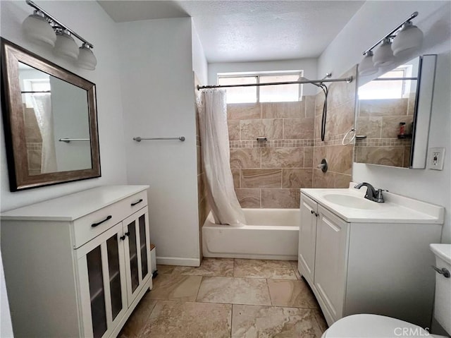 full bathroom with shower / bath combo with shower curtain, vanity, a textured ceiling, and toilet