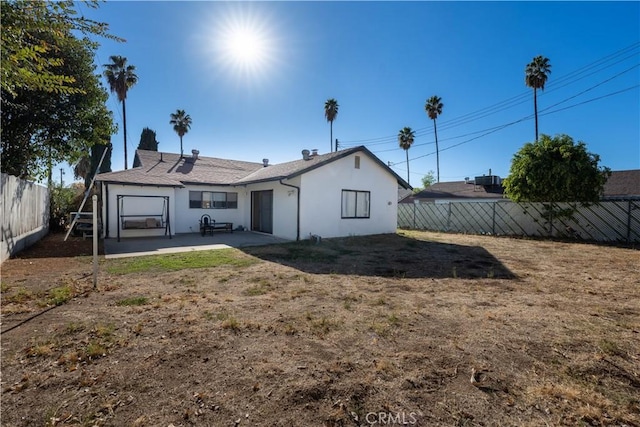 back of property with a yard and a patio